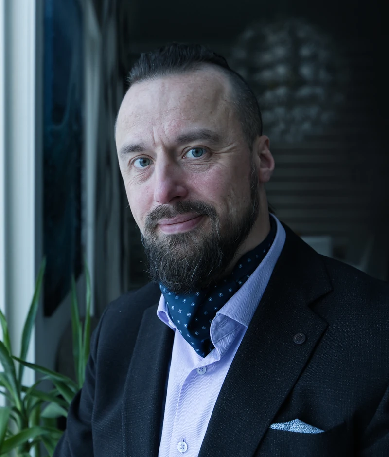 Leo Kokkonen puvussa ikkunan äärellä